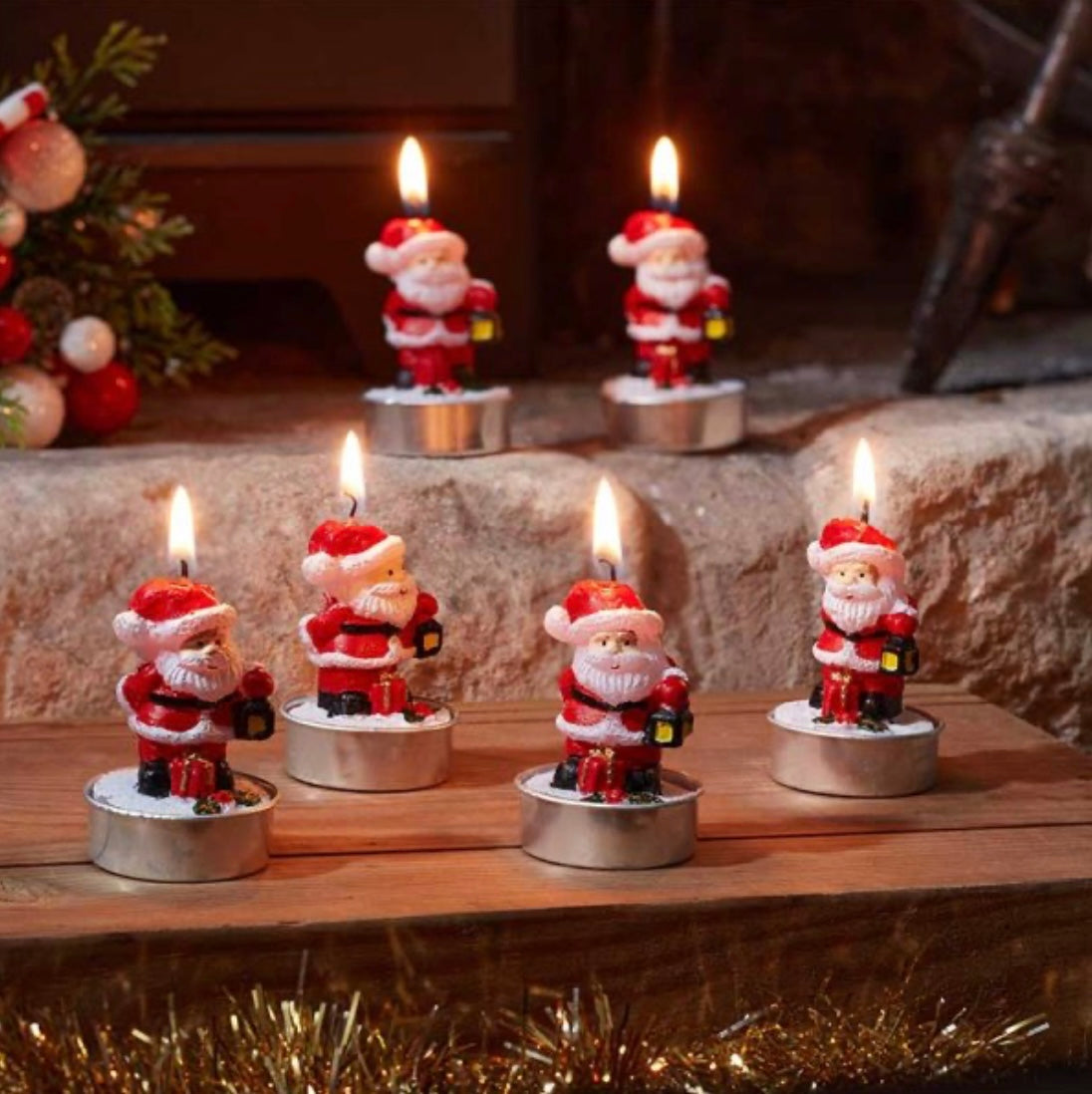 Set of Santa Claus candles on a wooden surface with a festive background.