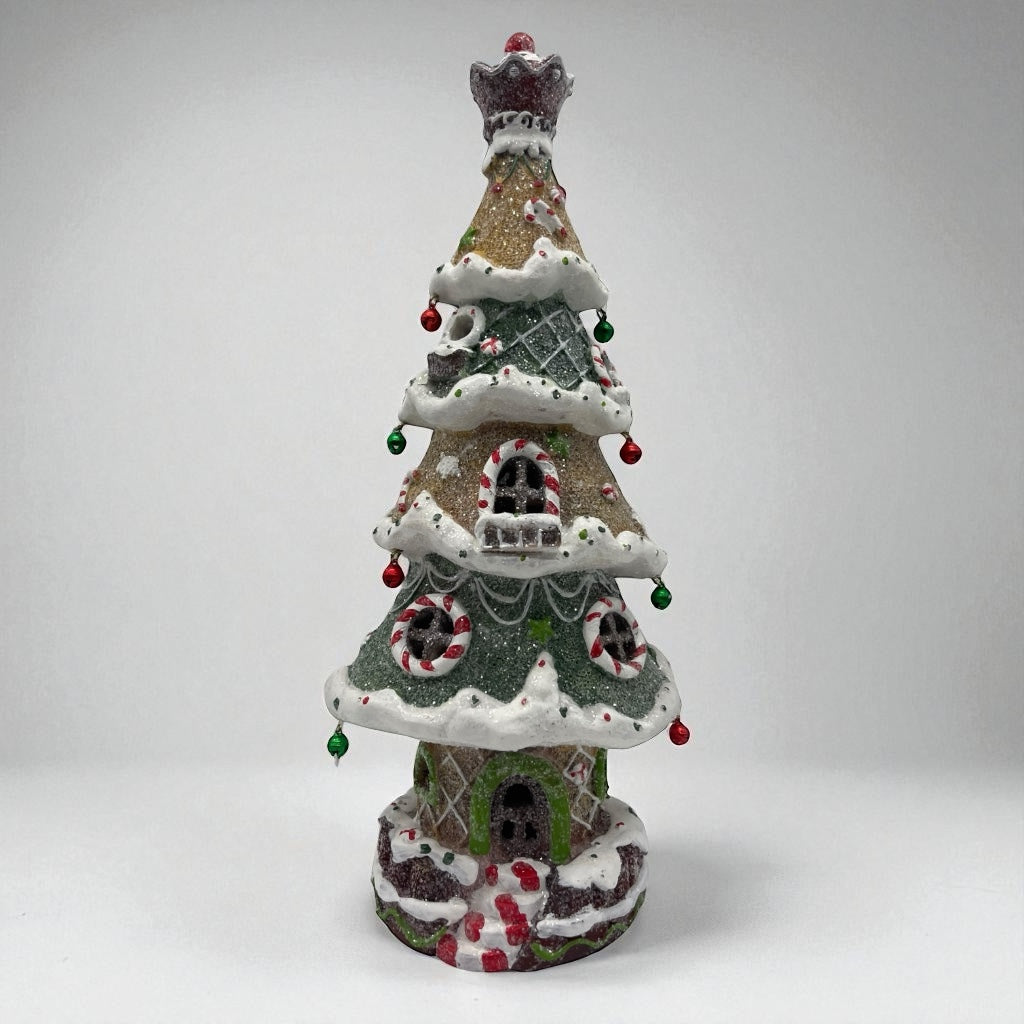 Decorative Christmas tree-shaped house with candy cane details on a white background