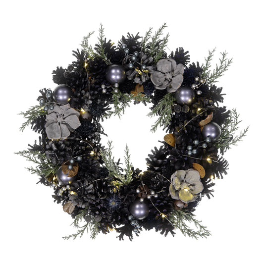 Decorative wreath with greenery, flowers, and ornaments on a white background