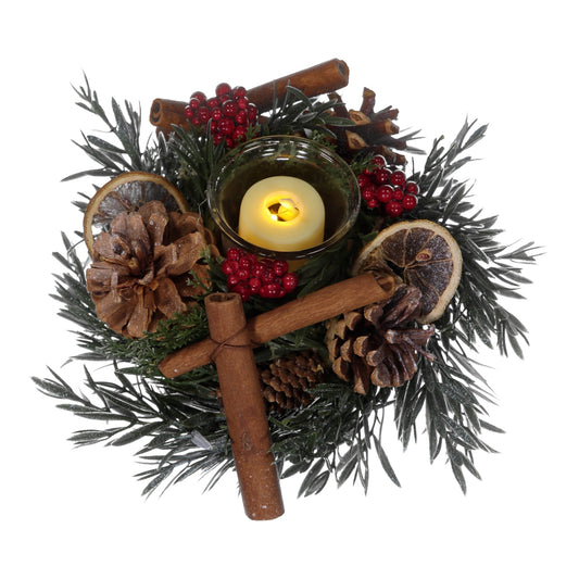 Decorative wreath with candles, cinnamon sticks, pine cones, and berries on a white background
