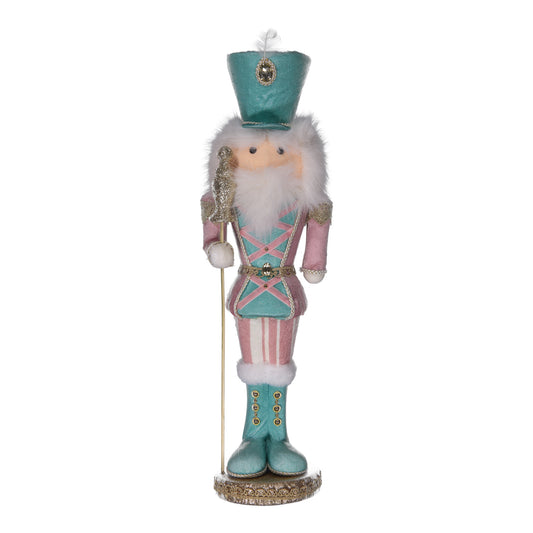 Decorative nutcracker figurine with teal outfit and white beard on a white background