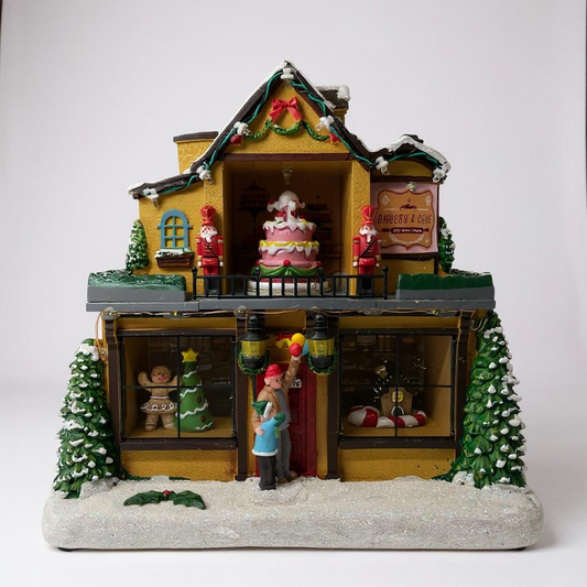 Decorative Christmas village scene with a house, Santa Claus, and trees on a white background
