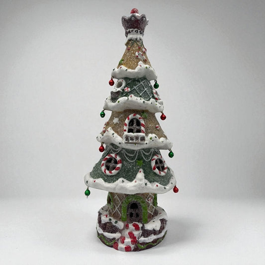 Decorative Christmas tree-shaped house with candy cane details on a white background