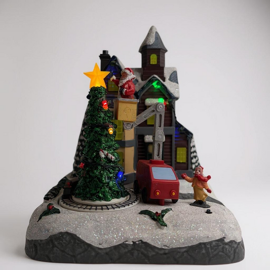 Christmas-themed village scene with a tree, house, and figures on a white background