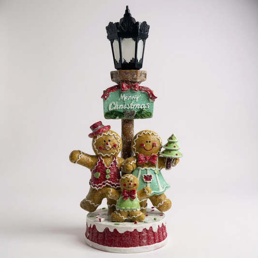 Decorative Christmas figurine with gingerbread people and a street lamp on a white background